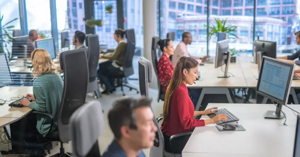 Group of technical support agents working at their desks in a modern office